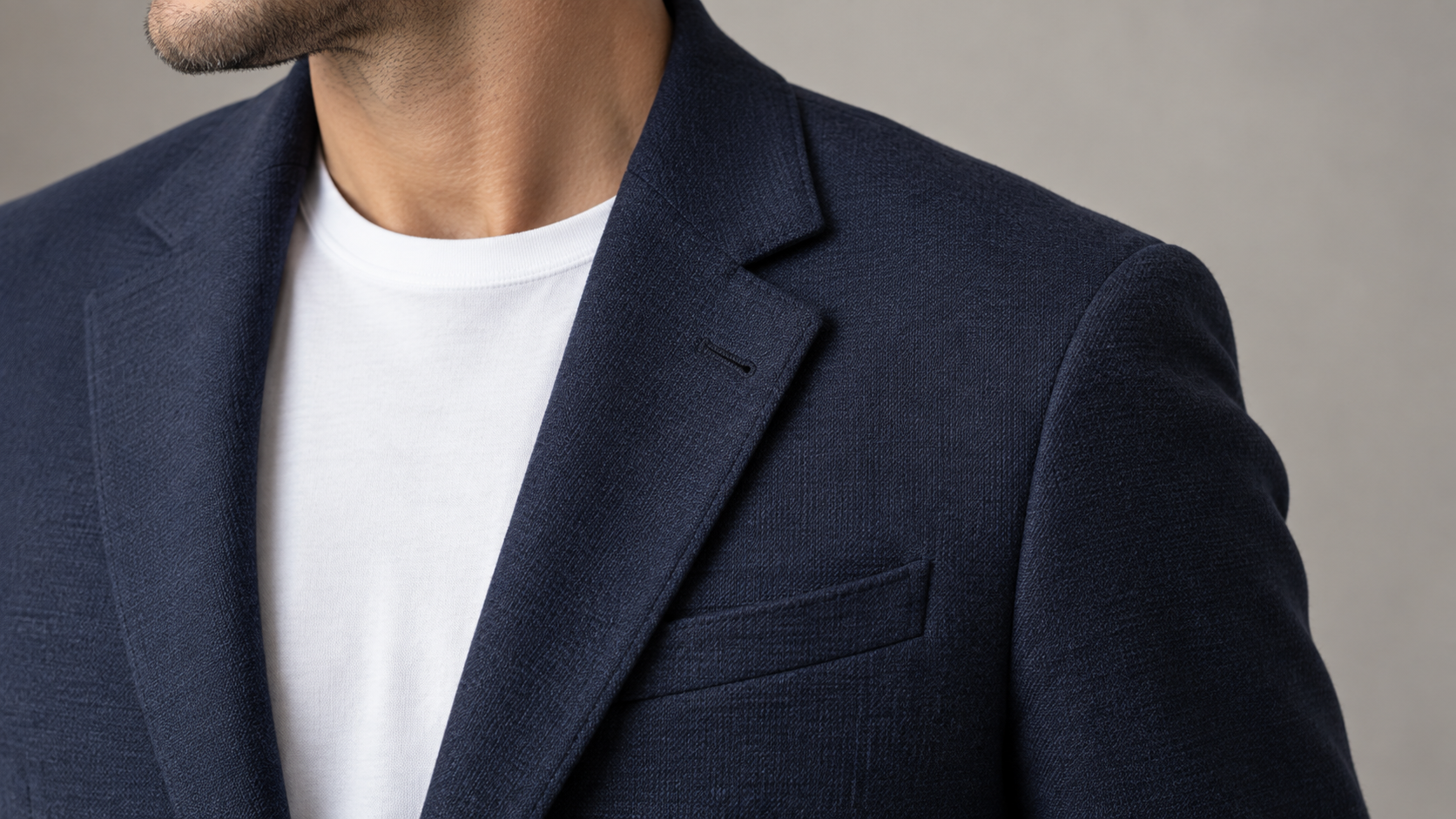 Gros plan d’un blazer bleu marine texturé avec revers et poche poitrine
